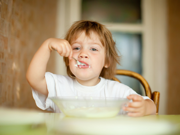 child eats with spoon